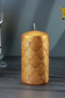 Gold pillar candle with embossed geometric pattern and rhinestone accents on a table, G Decor