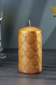 Gold pillar candle with embossed geometric pattern and rhinestone accents on a table, G Decor