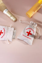 Pair of Hangover Kit Linen Gift Bags with Red Cross Design — lifestyle view, G Decor