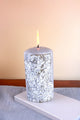 Decorative silver pillar candle with embossed leaf design on table, luxury G Decor home décor