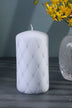 White luxury pillar candle with diamond pattern, next to crystal vase and yellow flowers, G Decor