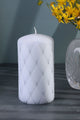 White luxury pillar candle with diamond pattern, next to crystal vase and yellow flowers, G Decor