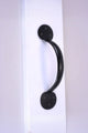 Black metal door handle on white surface, luxury hardware by G Decor
