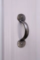 Silver metal cabinet pull handle on a white paneled door, G Decor luxury hardware