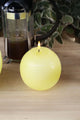 Yellow round candle lit on wooden table, French press and greenery behind, G Decor home décor