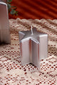 Silver star-shaped candle on lace tablecloth, luxury G Decor home décor accent.
