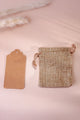 Natural jute drawstring pouch and kraft tag on a soft beige background, luxury home décor accessory.