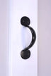Black metal door handle on white surface, luxury hardware by G Decor