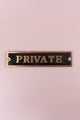Gold and black PRIVATE door sign by G Decor luxury hardware on a soft pink background.