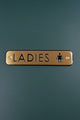 Gold ladies restroom sign with black engraving on dark green background, G Decor hardware