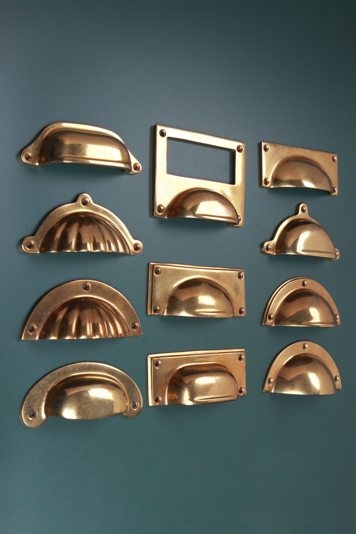 Eleven aged brass cup pulls, angled view
