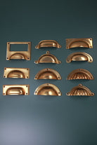 All eleven aged brass cup pull styles laid out together