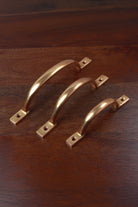 Three aged brass D handles — 4, 5 and 6 inch