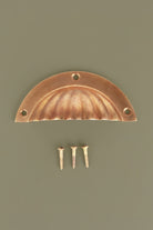 Fluted aged brass cup pull with its screws