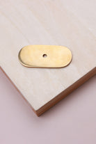 Aged brass oblong backplate, 54 x 25mm with rounded ends: solid brass with a 4mm centre hole for the knob bolt
