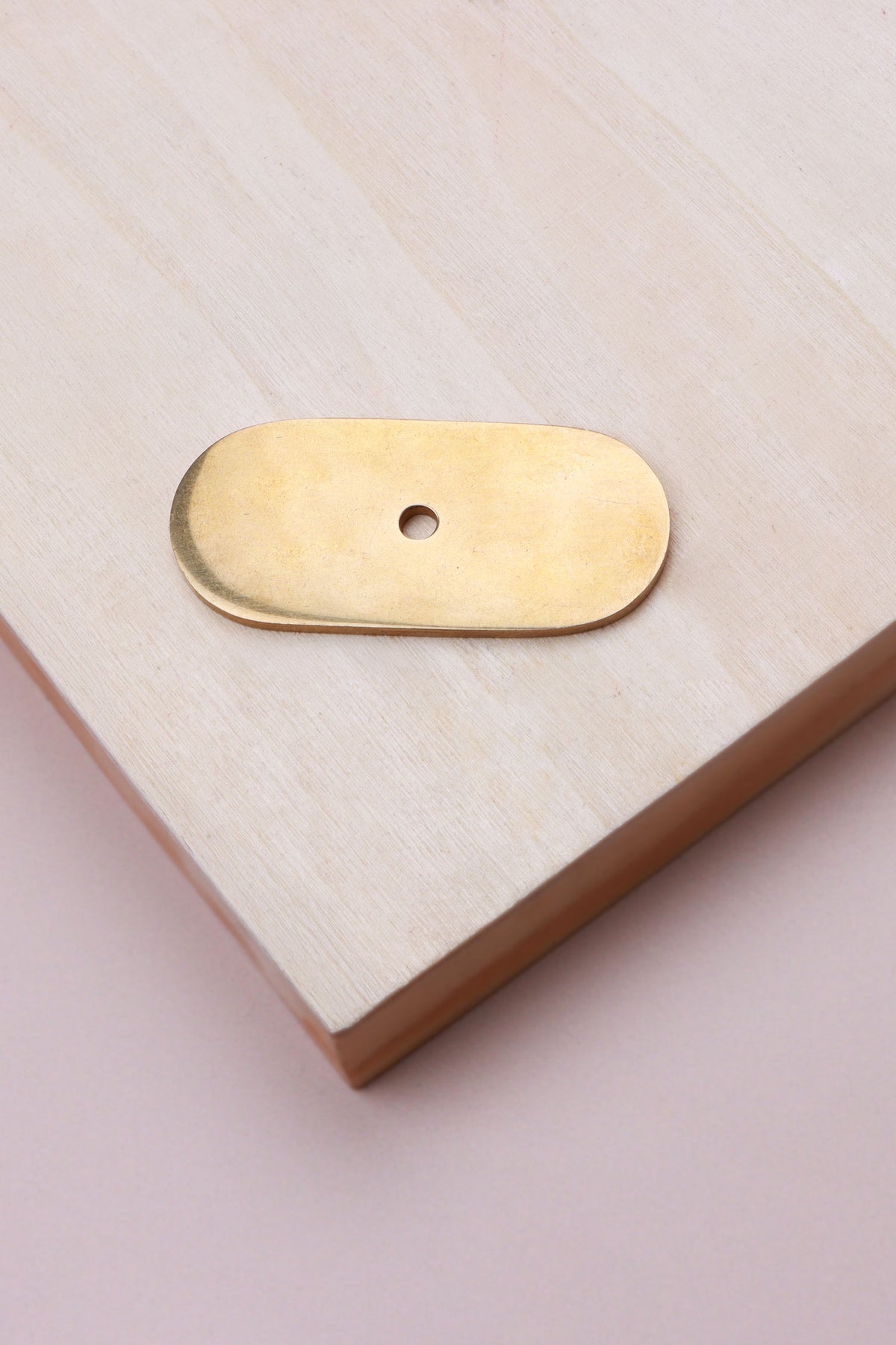 Aged brass oblong backplate, 54 x 25mm with rounded ends: solid brass with a 4mm centre hole for the knob bolt