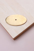 Aged brass oval backplate, 69 x 40mm: solid brass with a 4mm centre hole for the knob bolt