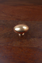 Aged brass oval cabinet knob on a stem