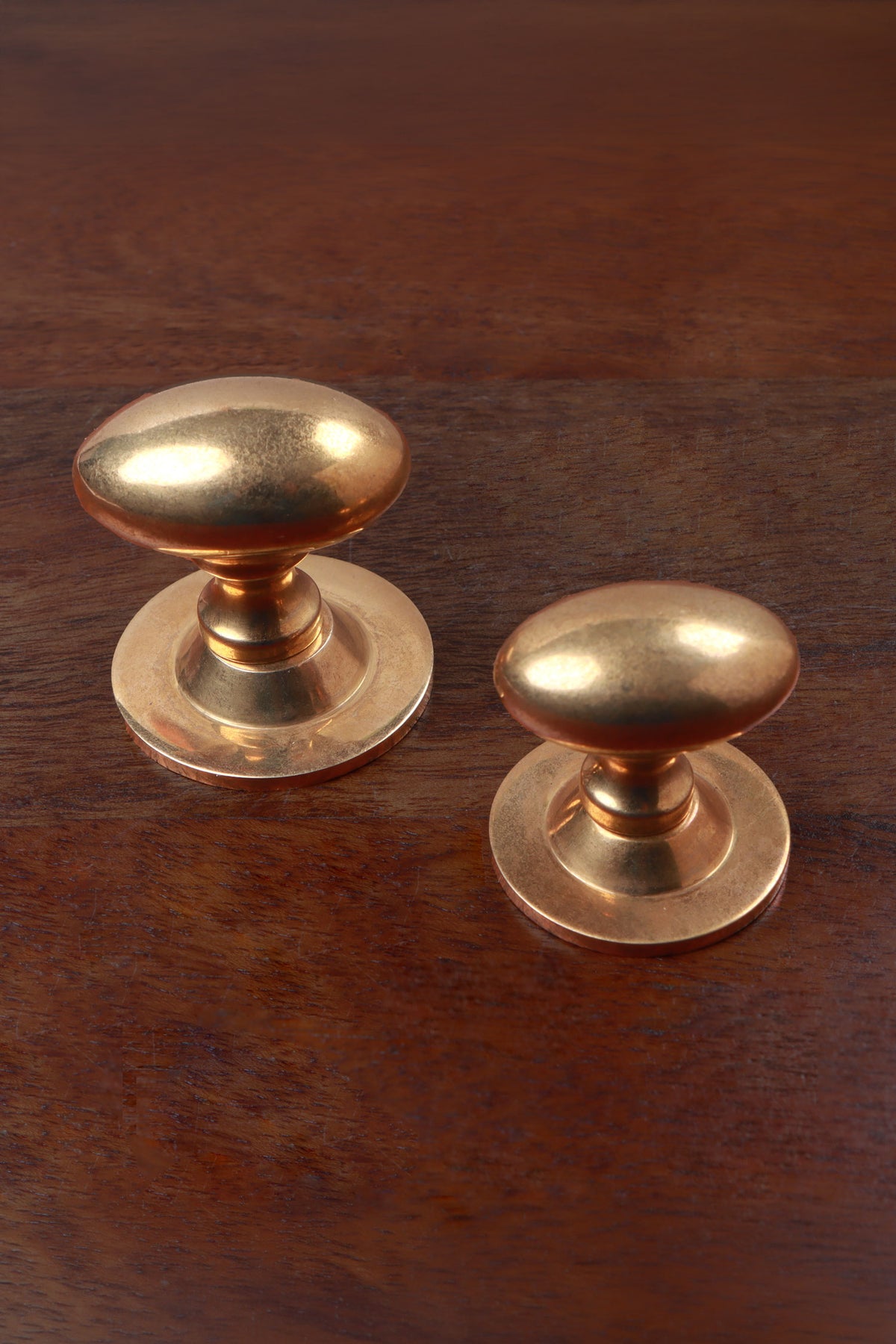 Aged brass oval knobs on roses, 38mm and 32mm