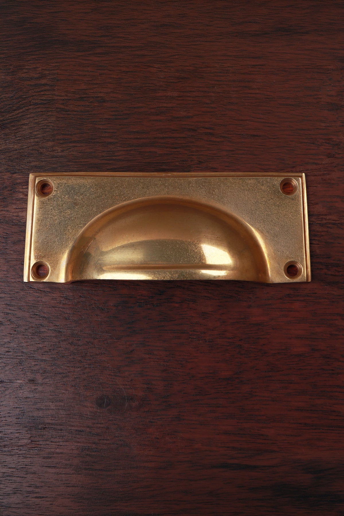 Rounded plate aged brass cup pull, 4 inch
