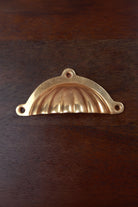 Scalloped aged brass cup pull with three fixing lugs