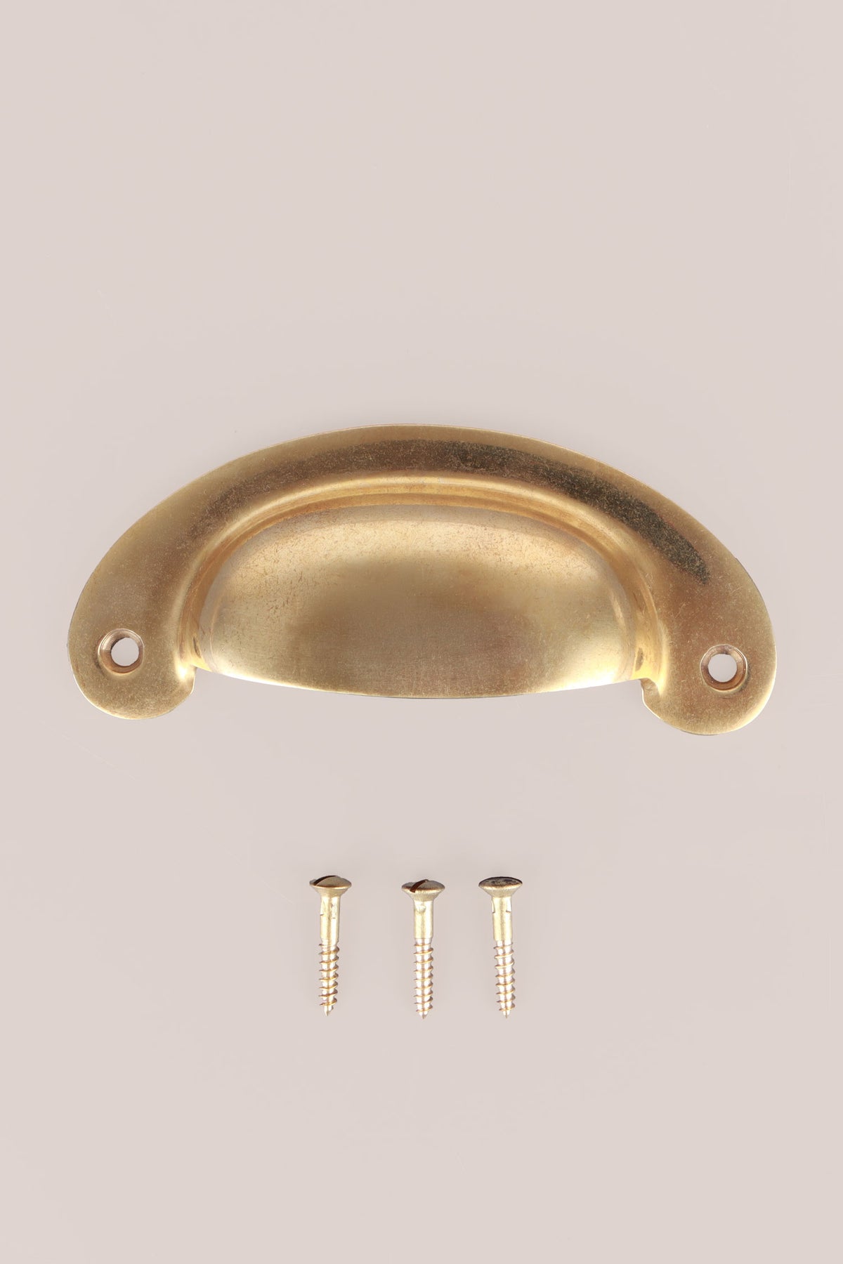 Slim crescent aged brass cup pull with its screws