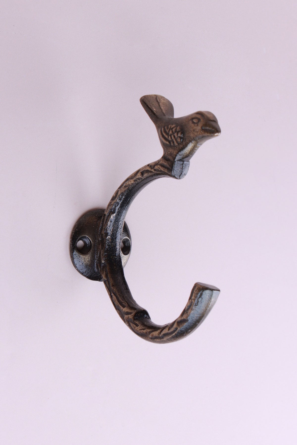 Bird Hook: cast iron single C-shaped hook with a small bird on top and a leaf pattern, on a round back plate, antique brass finish