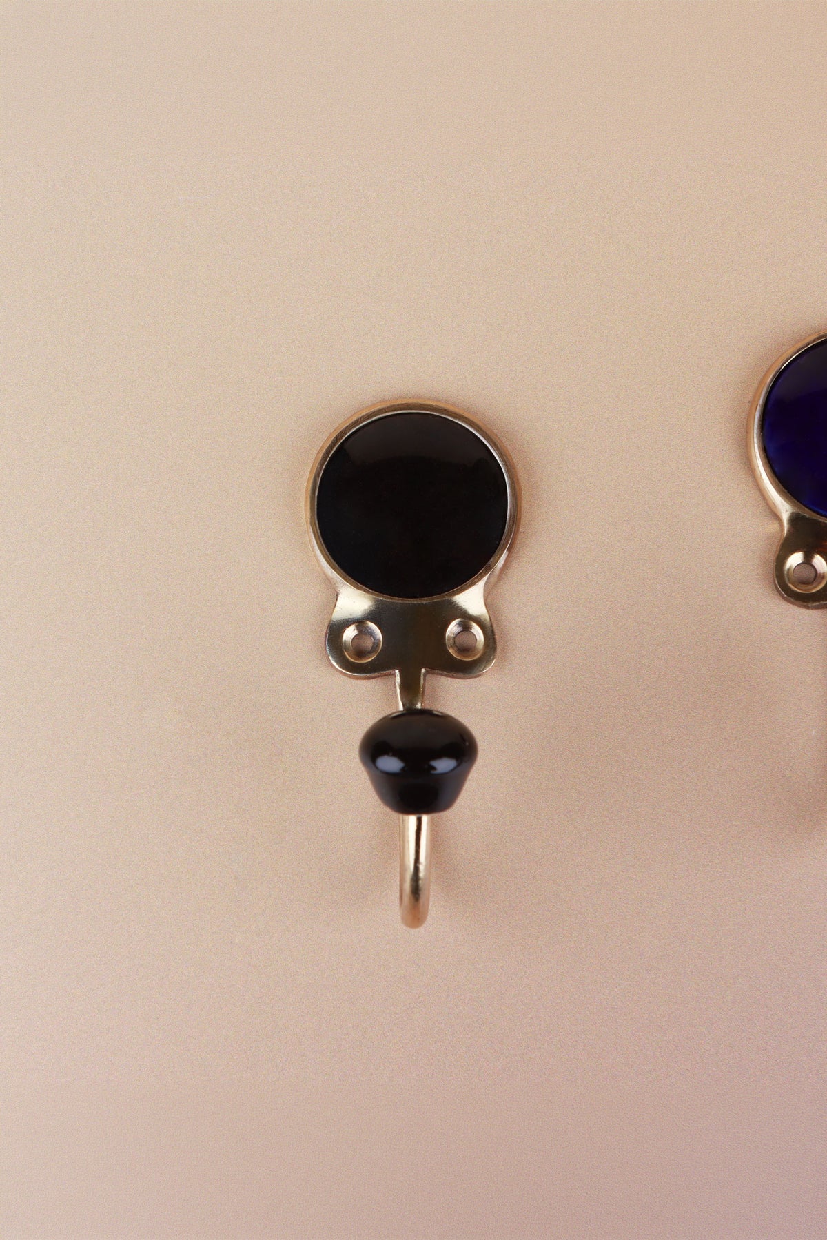 Black ceramic coat hook: black disc in a gold-tone frame with a black ceramic knob