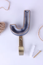 Blue ceramic letter hook J with a gold rim