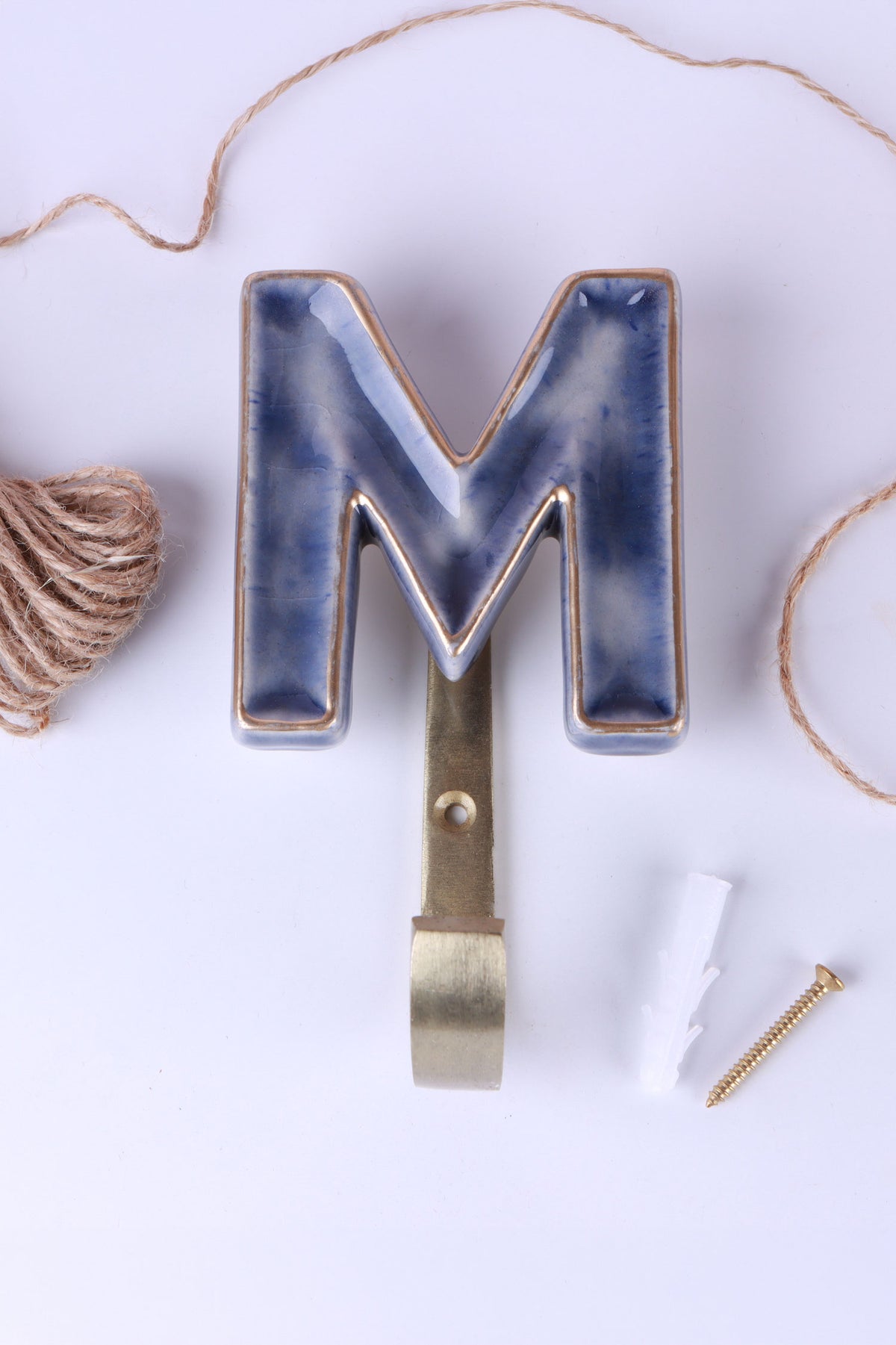 Blue ceramic letter hook M with a gold rim
