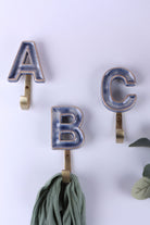Blue ceramic letter hooks on the wall, second view