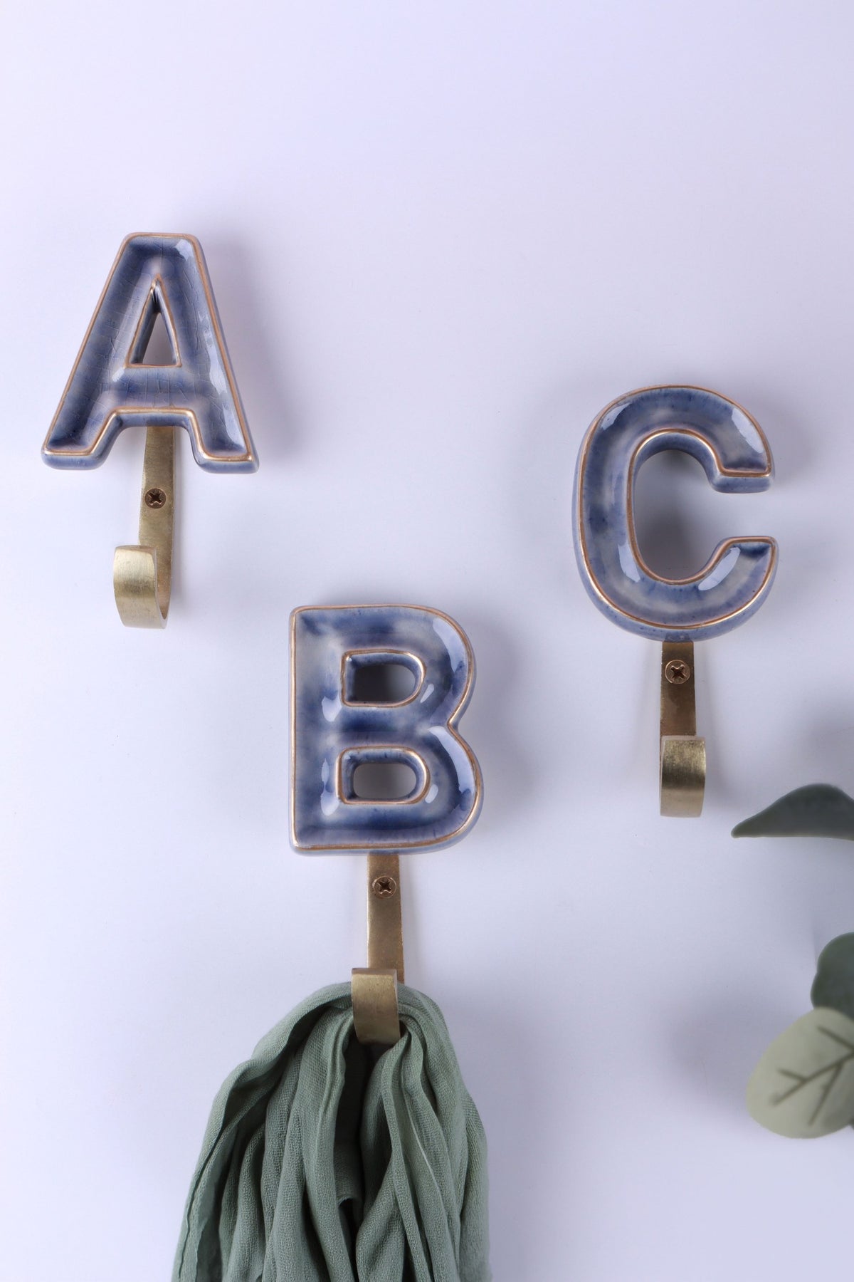 Blue ceramic letter hooks on the wall, second view