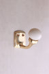 Cream ceramic ball hook: a cream ceramic ball on a curved brass-finish hook with a small back plate and two screws
