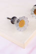 Grey daisy glass cabinet knob: frosted pale grey petals around an amber glass centre, on a ribbed glass stem and antique brass finish base