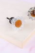 White daisy glass cabinet knob: frosted white petals around an amber glass centre, on a ribbed glass stem and antique brass finish base