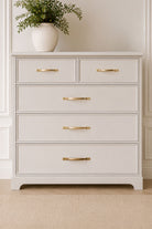 Brass cabinet D handles on drawer fronts in a room setting