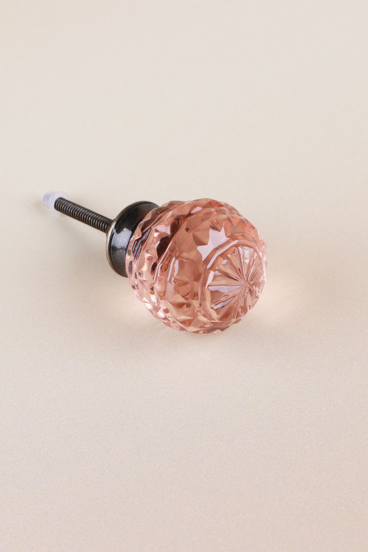 Blush Pink faceted glass ball cabinet knob, a soft rose tint, on an antique brass finish base with its fixing bolt