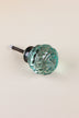 Teal faceted glass ball cabinet knob, a cool blue-green, on an antique brass finish base with its fixing bolt