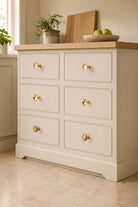 Flat brass cabinet knobs fitted to a cream painted chest of drawers