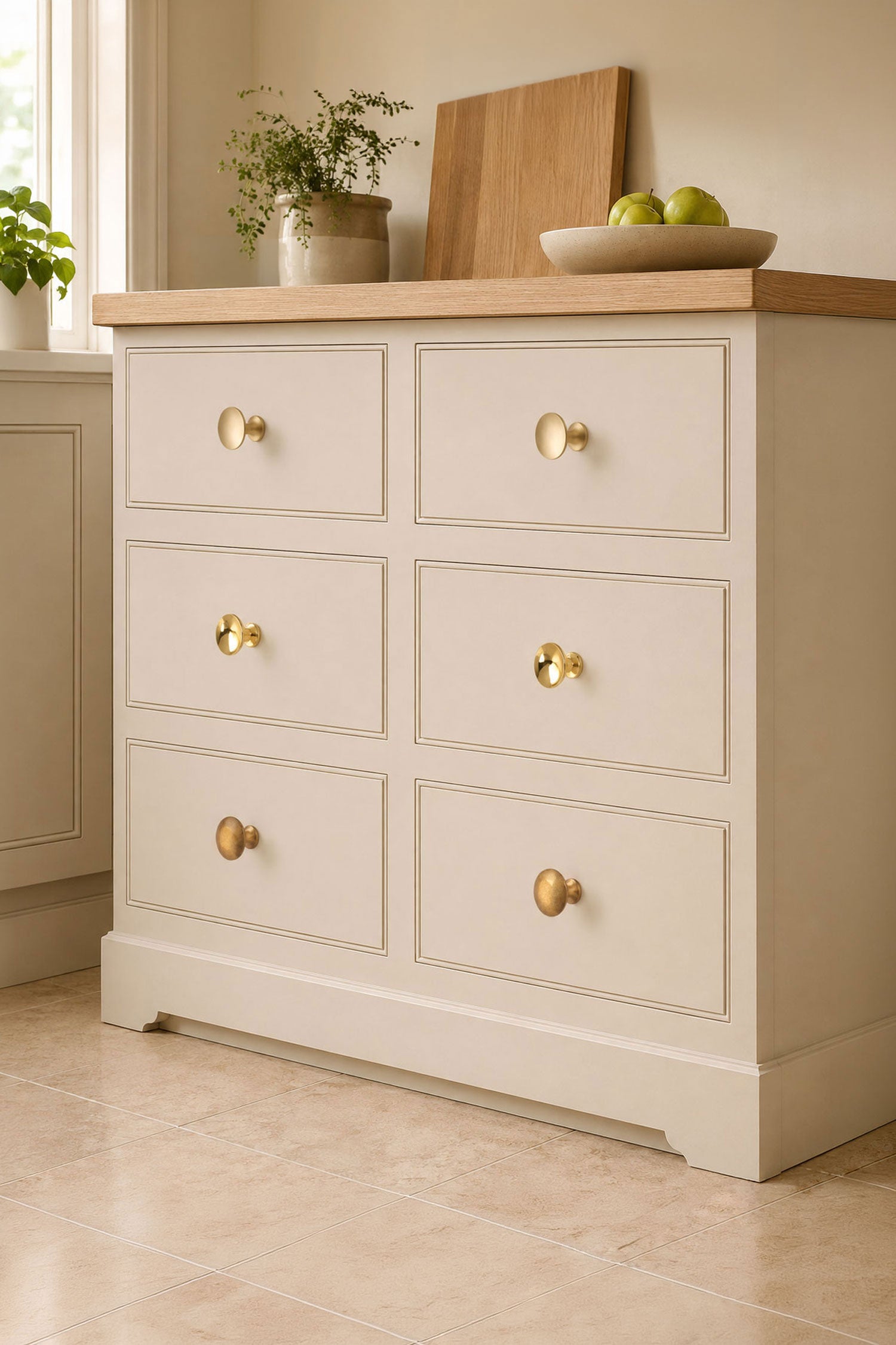 Flat brass cabinet knobs fitted to a cream painted chest of drawers