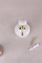 Cream floral ceramic wall hook with a lacquered brass hook