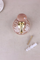 Dusky pink floral ceramic wall hook with a lacquered brass hook