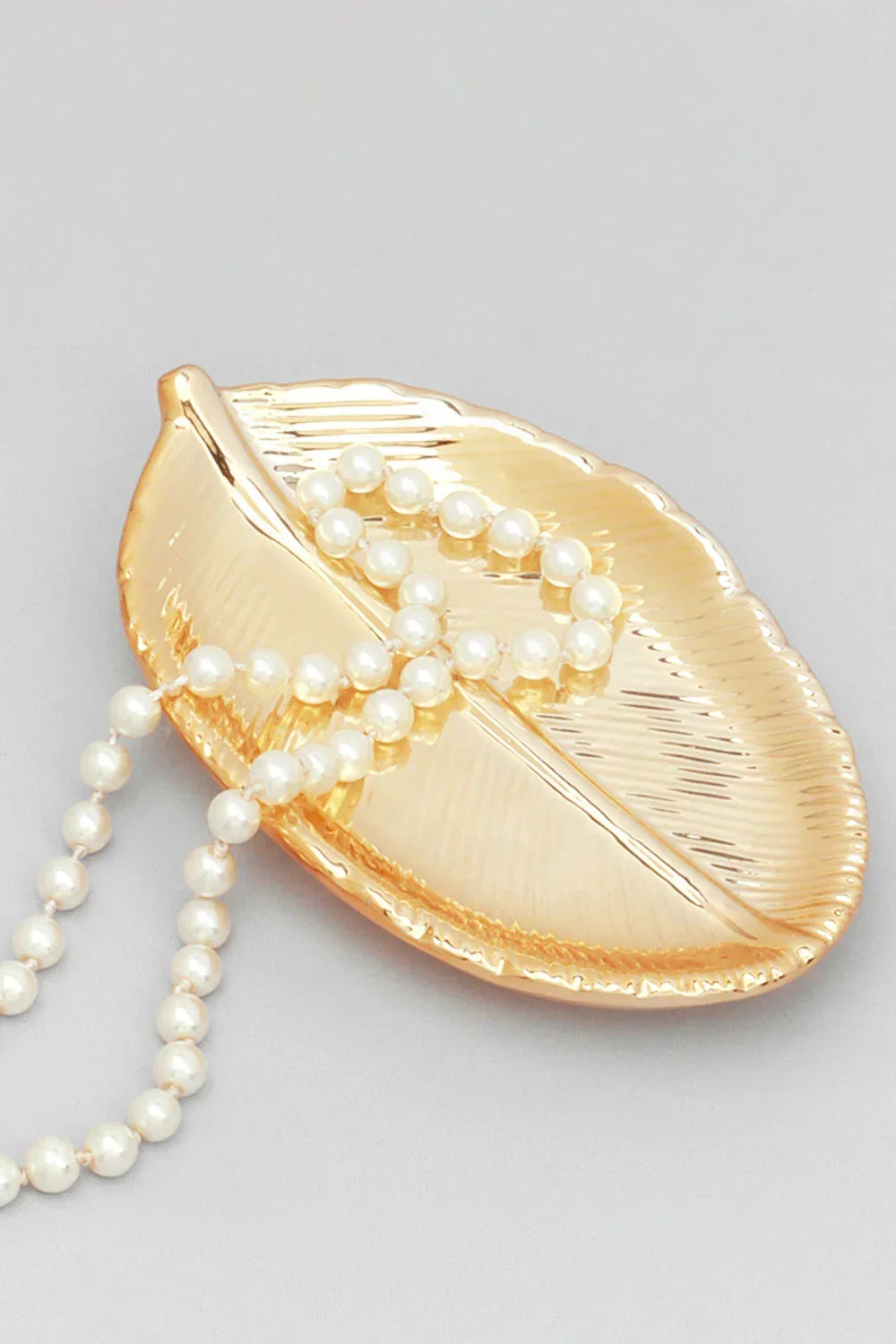 Plateau à bijoux texturé en métal brillant et orné de feuilles naturelles