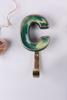 Green ceramic letter hook C with a gold rim