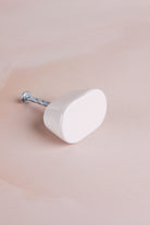 Cream oval ceramic cabinet knob with its fixing bolt