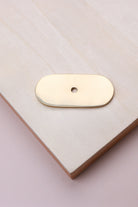 Polished brass oblong backplate, 54 x 25mm with rounded ends: solid brass with a 4mm centre hole for the knob bolt