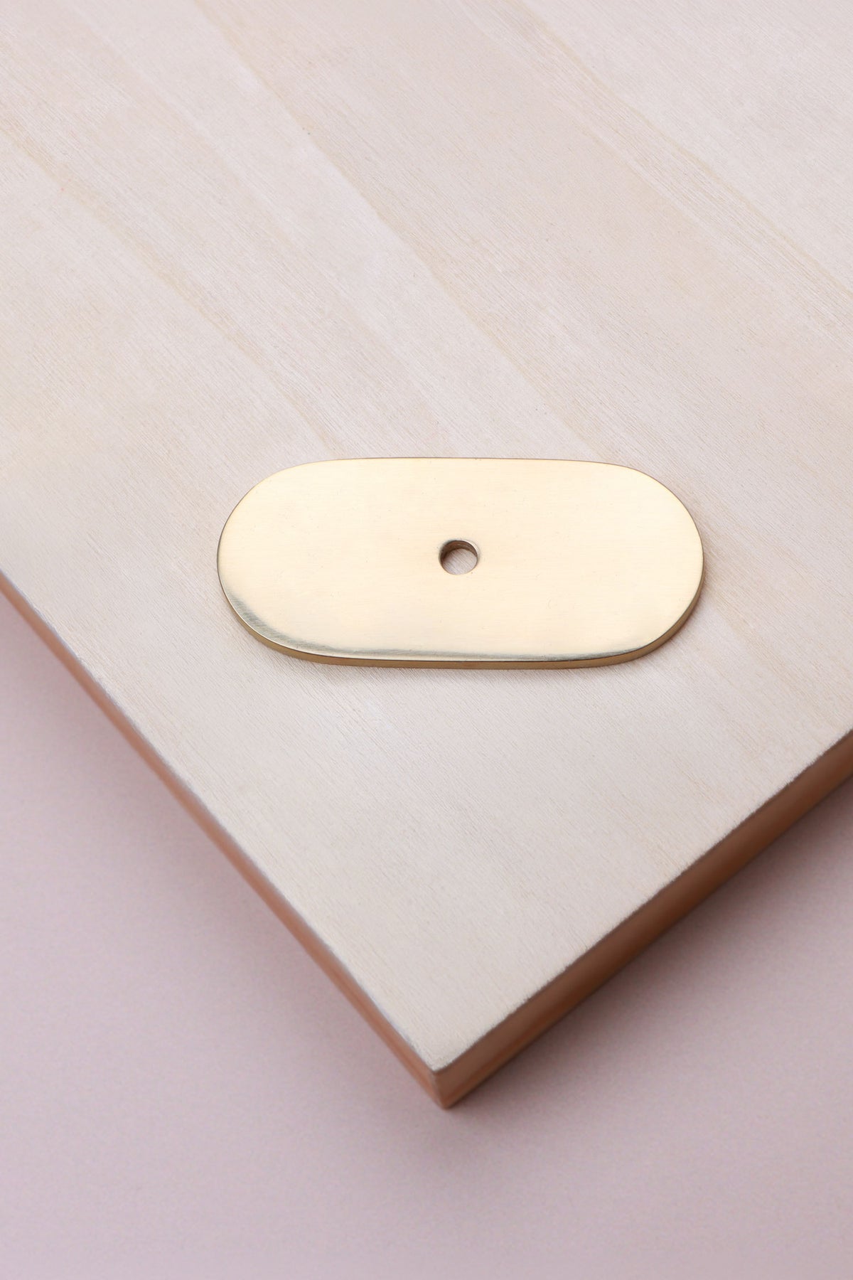 Polished brass oblong backplate, 54 x 25mm with rounded ends: solid brass with a 4mm centre hole for the knob bolt
