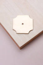 Polished brass square backplate, 50 x 50mm with scooped corners: solid brass with a 4mm centre hole for the knob bolt