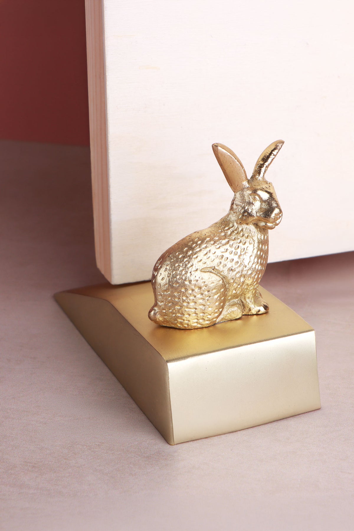 Rabbit door stopper in polished brass holding an interior door