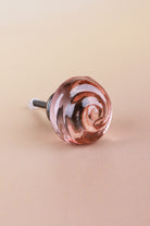 Blush Pink small rose glass cabinet knob, a soft rose tint, with a swirl curling into the centre, on an antique brass finish base